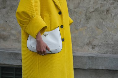 Milan, İtalya - 24 Eylül 2021: Sokak tarzı kıyafet, sarı Prada giysili şık bir kadın, Milano, İtalya 'da beyaz çanta.