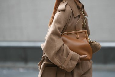 Milan, İtalya - 22 Eylül 2021: Sokak tarzı kıyafet, Fendi 'den altın büyük kolye takan şık bir kadın, Fendi' den altın zincirli bir FF kolye, siyah çizgili kahverengi ve FF monogramlı kesilmiş gömlek, bej balon h