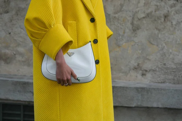 Milan, İtalya - 24 Eylül 2021: Sokak tarzı kıyafet, sarı Prada giysili şık bir kadın, Milano, İtalya 'da beyaz çanta.
