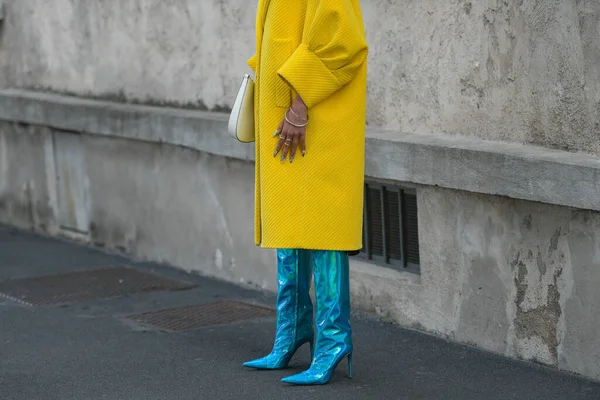 Milan, İtalya - 24 Eylül 2021: Sokak tarzı kıyafet, sarı kurdeleli kadife büyük bir ceket giyen şık kadın, Prada 'dan beyaz deri bir omuz çantası, gümüş bilezikler, gümüş yüzükler, mavi parlak deri topuklu koruyucular, çizme