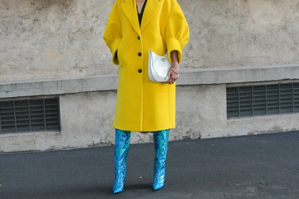 Milan, İtalya - 24 Eylül 2021: Sokak tarzı kıyafet, sarı kurdeleli kadife büyük bir ceket giyen şık kadın, Prada 'dan beyaz deri bir omuz çantası, gümüş bilezikler, gümüş yüzükler, mavi parlak deri topuklu koruyucular, çizme