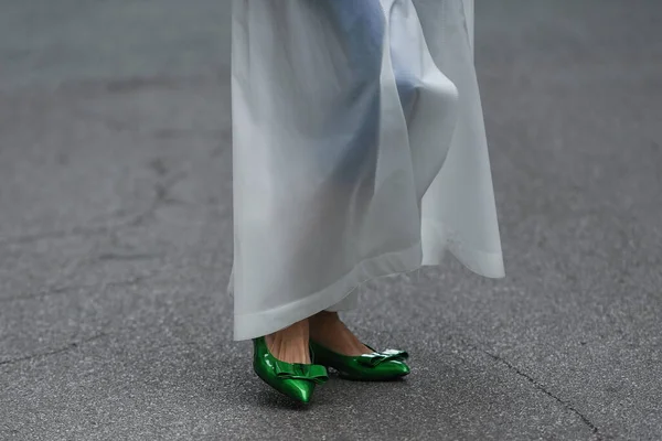 Street style outfit - woman wearing shiny dark green shoes and white transparent dress