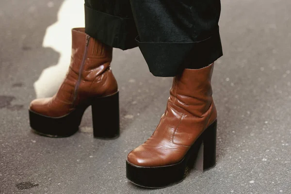 Street style outfit - woman wearing brown leather platform shoes and black leather skirt