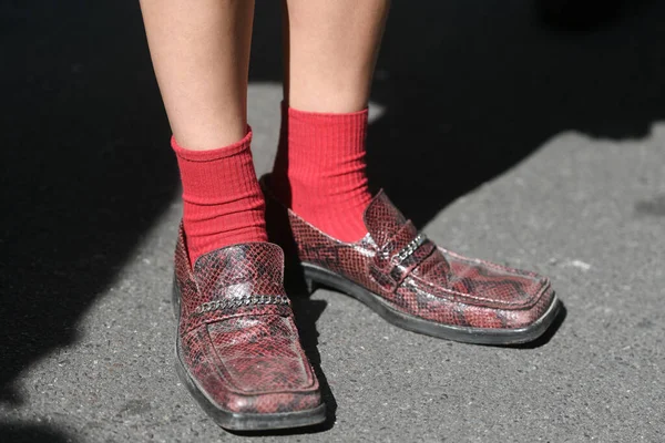 Street style outfit - woman wearing snake leather shoes and red socks
