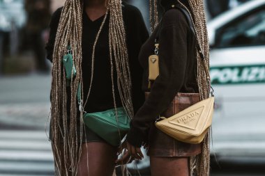 MILAN, İTALYA - 24 Şubat: sokak tarzı kıyafet - Prada çanta ve ayakkabı giyen kızlar.