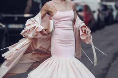 Street style, woman wearing a pale pink tank-top tube knees with embroidered pale pink midi dress, a pale pink oversized long trench coatand pink strappy sandals. clipart
