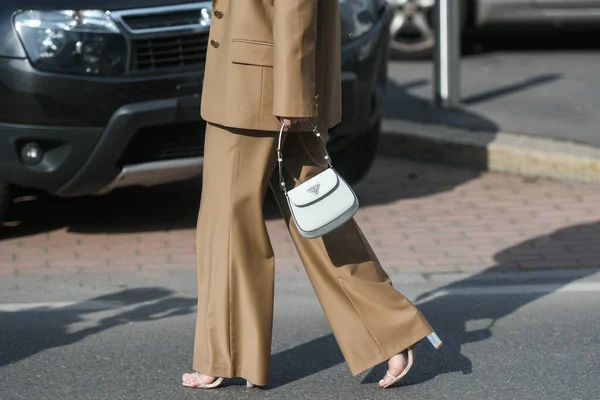 意大利米兰2月24日 街道风格 身着普拉达套装的女人 棕色超大运动衫 棕色大裤子 白色闪亮皮革清洁手袋 犀牛高跟鞋鞋 — 图库照片