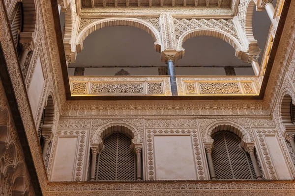 Editör: SEVILLE, ANDALUSIA, SPAIN, 11 Ekim 2021 - Seville Alcazar 'daki bakirelerin avlusunun üst katlarında zengin süslemeler