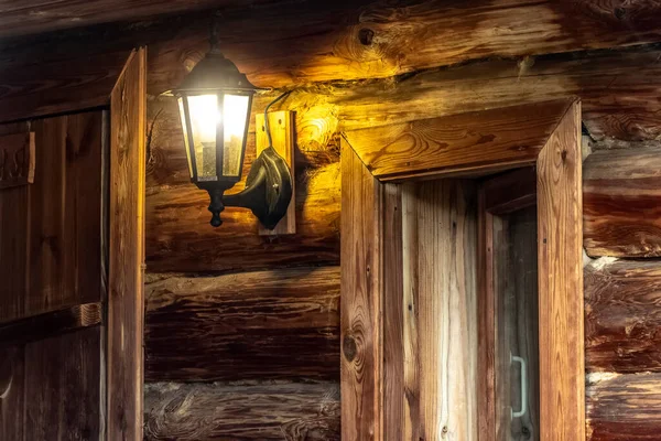 古い木造ログハウスの壁にランプ — ストック写真