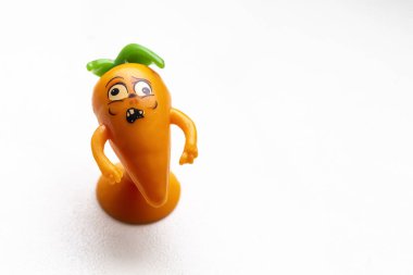 Beyaz arka planda küçük bir havuç heykeli..