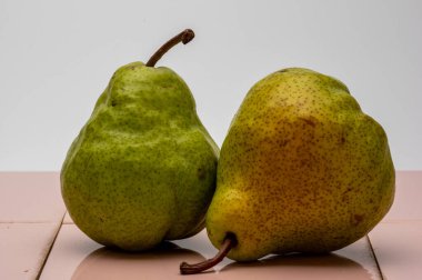 Pembe kiremit üzerine beyaz arka planı olan Armut Pakham