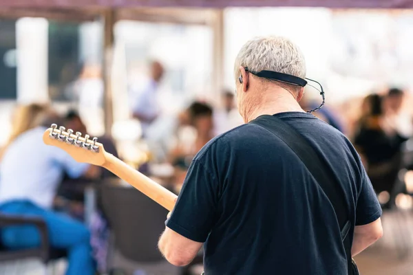 Powrót starszego człowieka grającego na gitarze elektrycznej na koncercie na tarasie — Zdjęcie stockowe