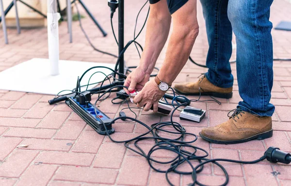 Звуковий технік збирає кабелі з підлоги після живого концерту — стокове фото