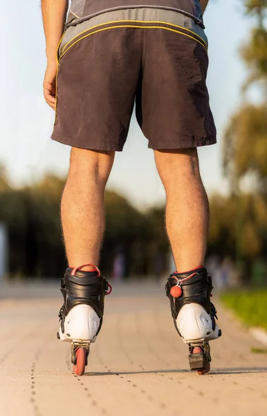 Vertikale Aufnahme der Beine eines Mannes, der mit Inlineskates läuft — Stockfoto