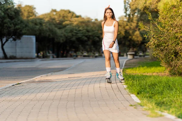 在公园旁边的人行横道上滑冰的妇女 — 图库照片