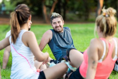 Parkta içsel sake içen bir grup arkadaş arasındaki bir adama odaklan.