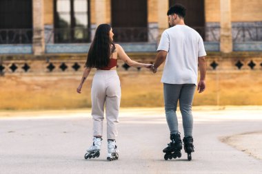 Sırtlarında iki çift dışarıda el ele kayıyorlar.