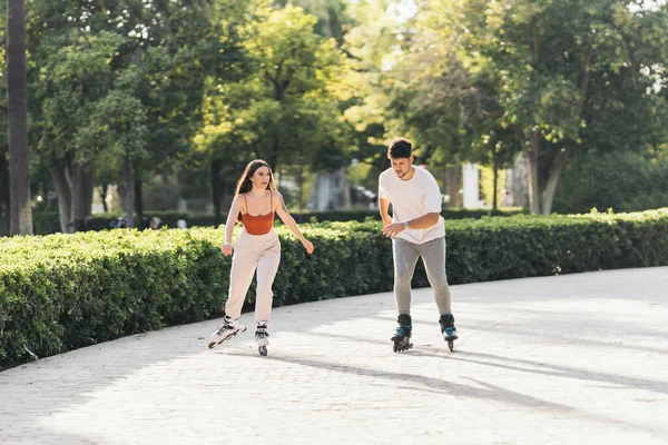 Giovani che pattinano con pattini in linea in una superficie pavimentata di un parco — Foto Stock