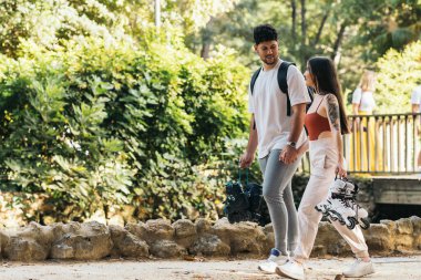 El ele tutuşan ve dışarıda paten taşıyan bir çift.