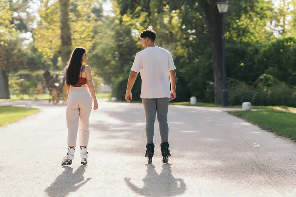 两个年轻朋友带着冰鞋在公园里滑冰 — 图库照片