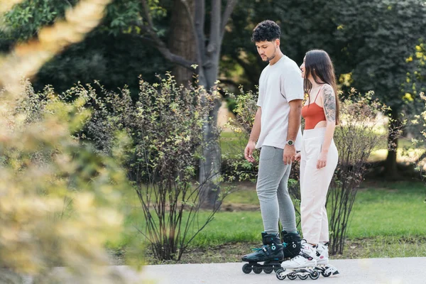 Молоді латиноамериканці саке з вбудованими ковзанами в парку — стокове фото