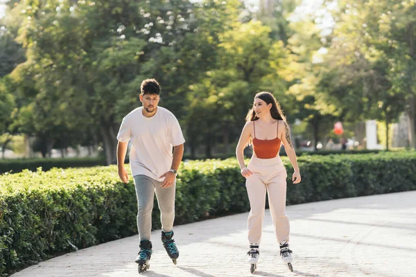 Giovani che pattinano rilassati utilizzando pattini in linea in un parco — Foto Stock