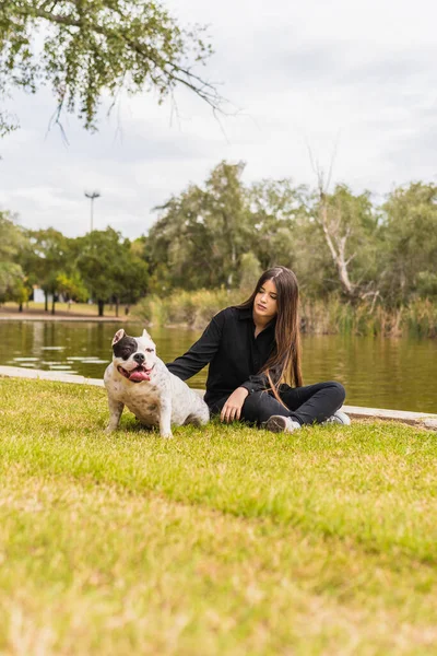 Ung hona klappa en hund sittande bredvid en flod — Stockfoto
