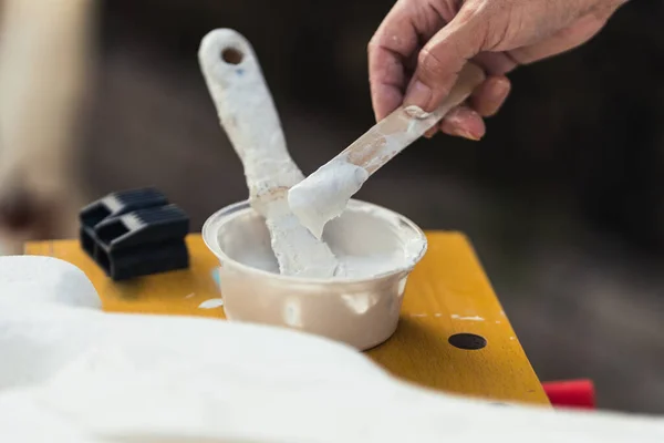 Человек, макающий белую пасту с лопаткой в мастерской — стоковое фото
