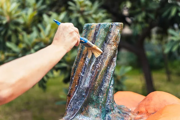 Руки женщины, использующей кисть, чтобы нарисовать тыкву — стоковое фото