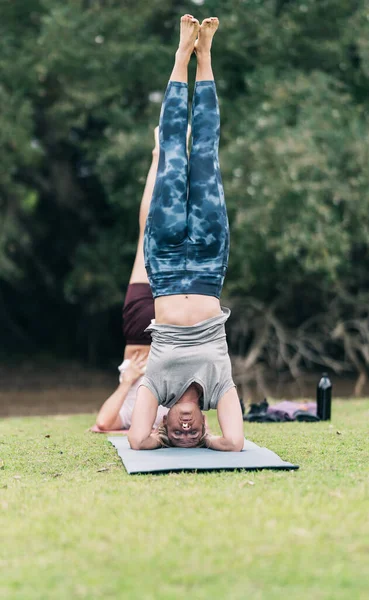 Люди, практикующие йогу в обратном положении в парке — стоковое фото