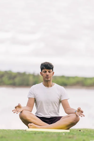 Atletische man die de lotuspositie van yoga buiten doet — Stockfoto