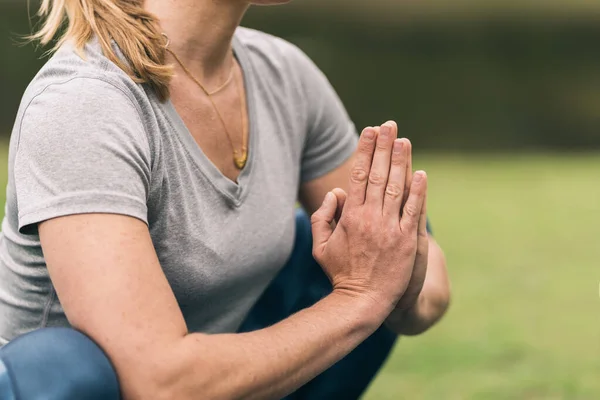 Handen van een vrouw palm aan palm terwijl het doen van een yoga buiten — Stockfoto