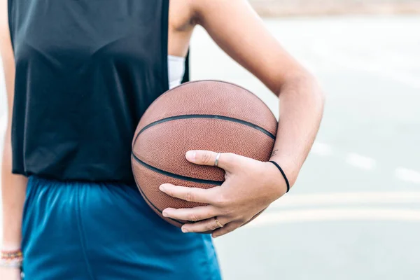 Foto ritagliata di una donna che tiene un pallone da basket in mano all'aperto — Foto Stock