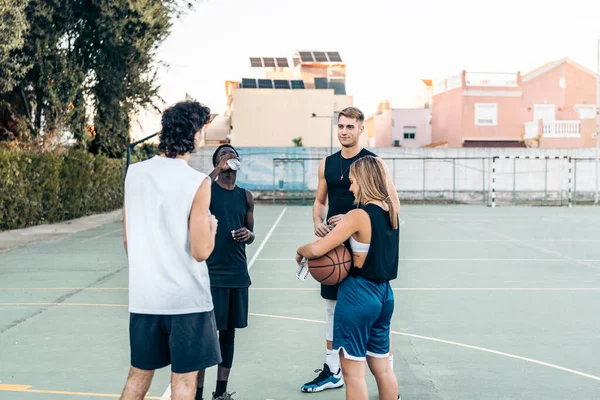 Amici in piedi con una pallacanestro in un campo all'aperto — Foto Stock