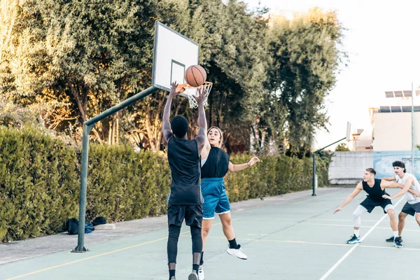 Quattro amici che giocano a basket in una corte pubblica all'aperto — Foto Stock