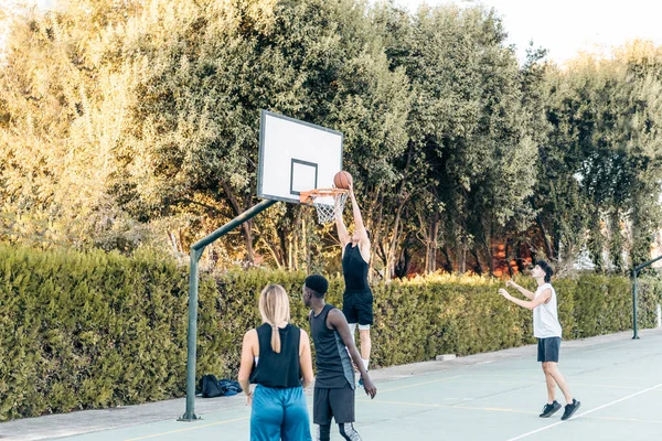 Uomo alto segnare durante una partita di basket in un campo aperto — Foto Stock