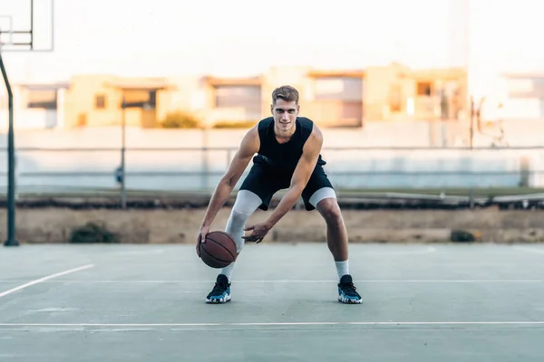 Basketballspieler lässt den Ball auf einem Außenplatz hüpfen — Stockfoto
