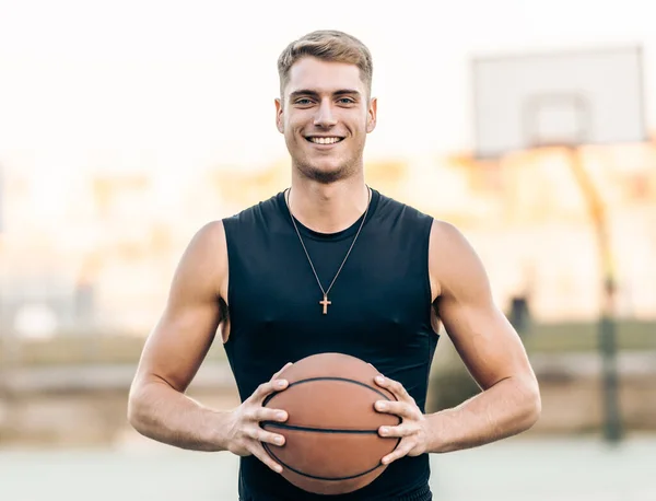 Uomo atletico caucasico che tiene un pallone da basket all'aperto — Foto Stock