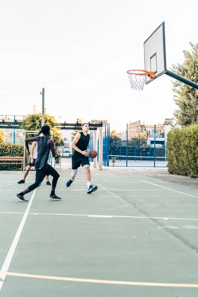 Foto verticale di un gruppo di amici che giocano a basket in uno spazio esterno — Foto Stock