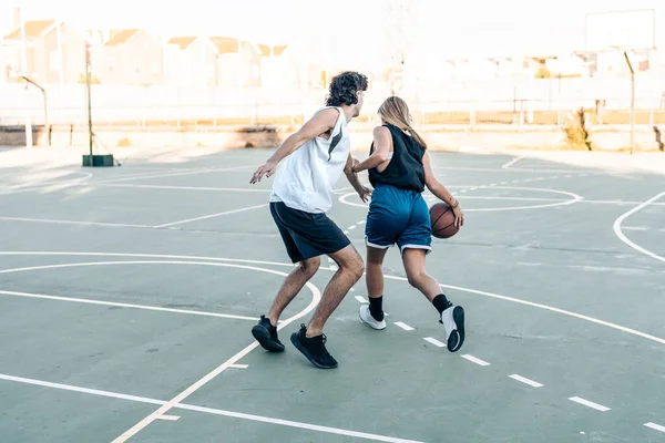 Dışarıda basketbol oynarken top sektiren kadın.