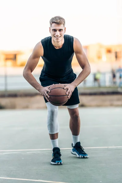 Jogador masculino posando enquanto segurava um basquete ao ar livre — Fotografia de Stock