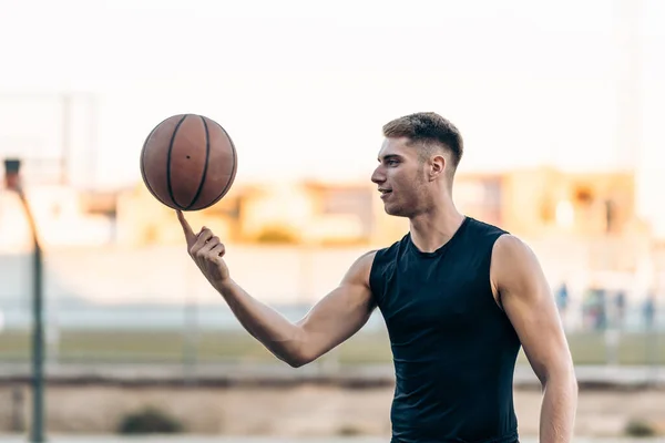 Giocatore di basket giocoleria una palla su un campo all'aperto — Foto Stock