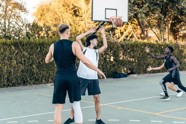 Man passing a ball during a basketball game between friends in an outdoor court — Foto Stock