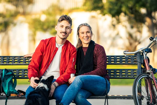 Портрет пари, що сидить на лавці з собакою — стокове фото