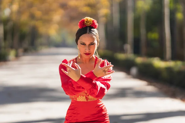 Bailarina de flamenco vestida de rojo con claveles en la cabeza bailando al aire libre —  Fotos de Stock