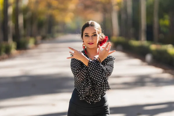 Woman in flamenco costume dancing while facing the camera in a park — Fotografia de Stock