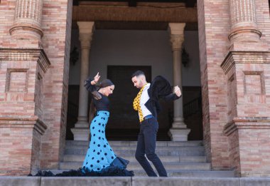 İki flamenko dansçısı bir binanın merdivenlerinde gösteri yapıyor.