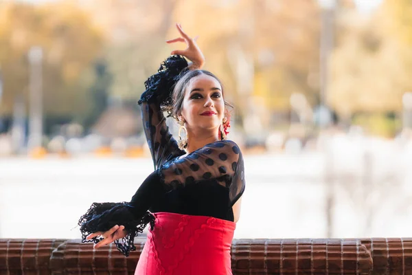Donna che balla il flamenco mentre alza le mani e indossa un abito tradizionale — Foto Stock