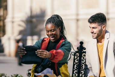 Surprised african woman holding a hat she has just received as a present