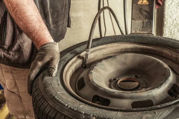 Close up view of a mechanic inflating a tyre with an automatic tool — Foto de Stock
